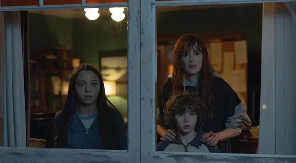 A woman and two children look out of a window in "La última noche en Tremor".