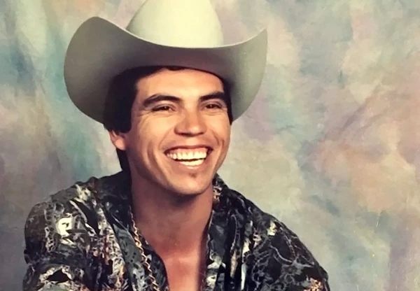 Chalino Sánchez smiles brightly, embodying charm in "El Rey del Corrido".