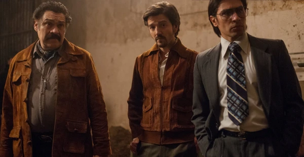 Three men in a tense scene from Narcos: Mexico.